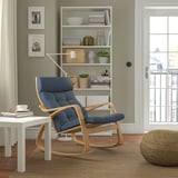 This image a stylish blue POÄNG rocking chair, made of oak veneer and soft poly-blend cushions, perfectly situated in a cozy living space.