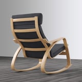 Black cushioned rocking chair with wooden frame on wooden floor.