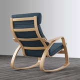 A light blue cushioned rocking armchair with a high back and wooden frame on a gray floor.