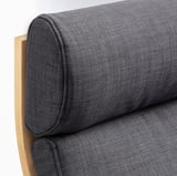 Close-up of sleek, modern sofa with curved wooden armrest and cushioned seat, highlighting quality and comfort.