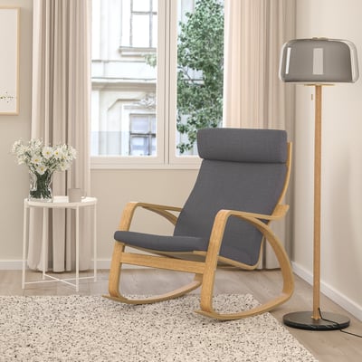 POÄNG rocking chair with cushion near lamp and window, cozy corner piece.