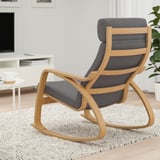 Modern rocking chair with light wood frame and gray cushions sits on a textured carpet in a cozy living room.