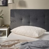 RÅDHUSVIN pillow: gray, gray linen headboard, white bed, cozy, natural fibers.
