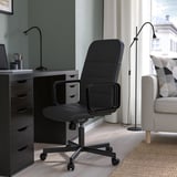 Black RENBERGET office chair in modern home office with desk & sofa.