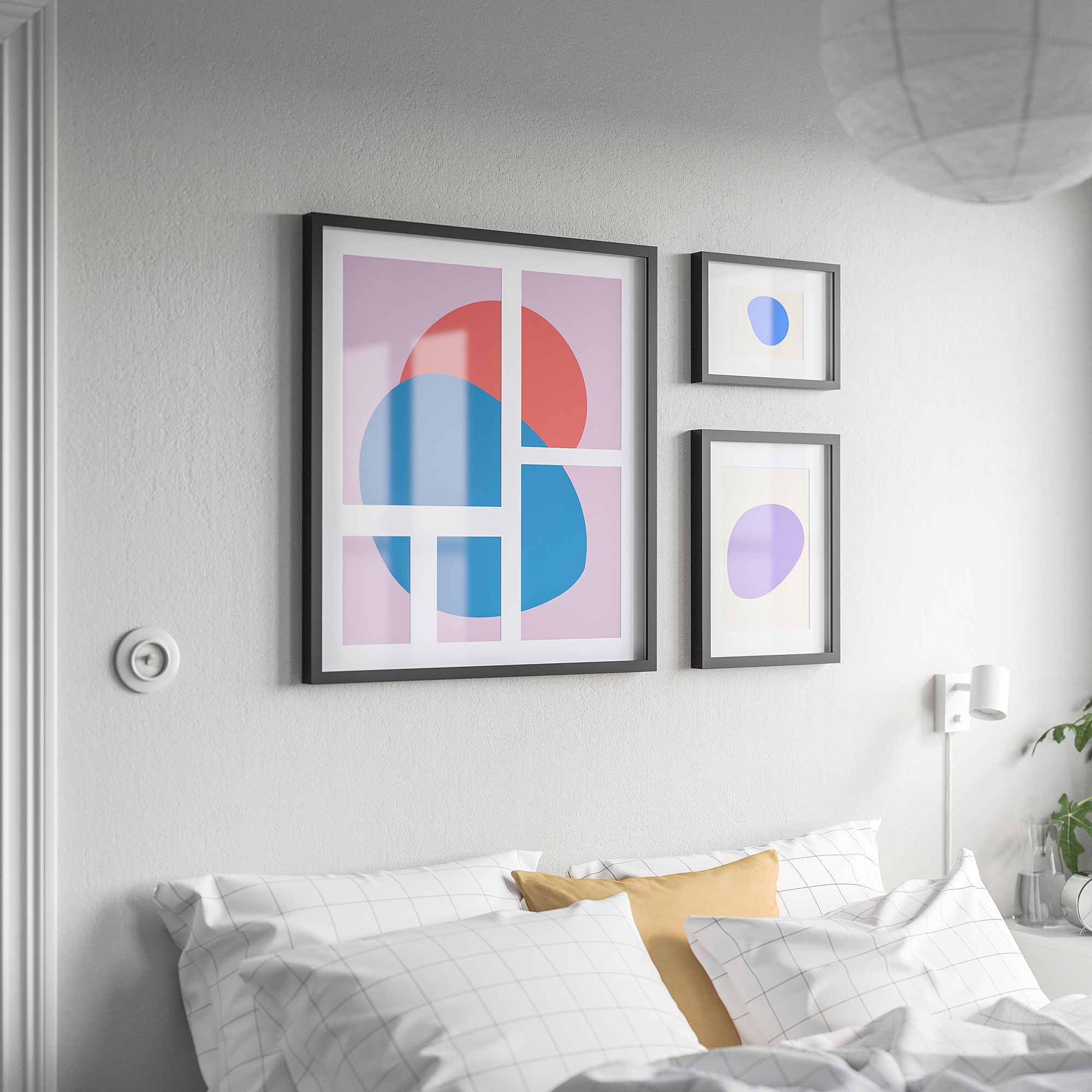 Bed with three abstract artworks: central geometric, two soft colors.