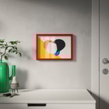 Red-framed artwork on wall, beside green vase and door.