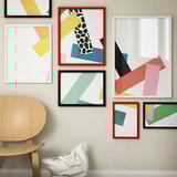 Colorful gallery wall with red RÖDALM abstract art frame, contrasting neutral furniture.