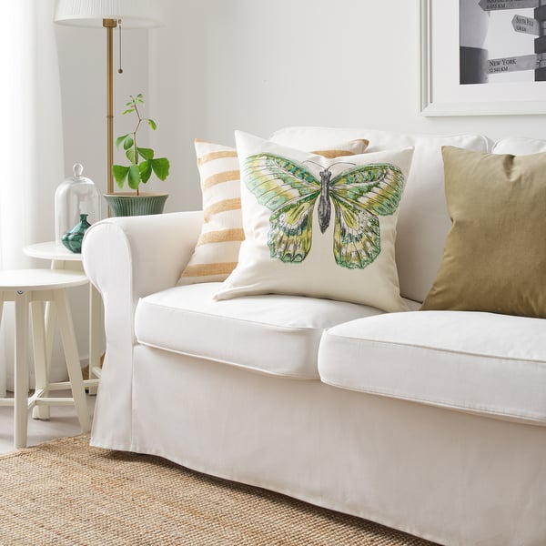 Square ROTFJÄRIL pillow with butterfly design on a white couch, mix of colors, ramie & cotton, stands out.