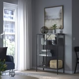 Modern living room with gray RUDSTA cabinet, large art, and blue chair.