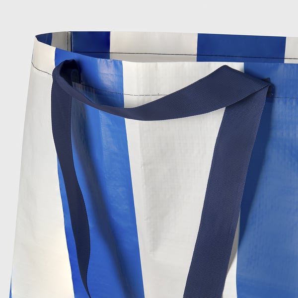 Blue and white shopping bag with strong handles shown in close-up, highlighting fabric quality.