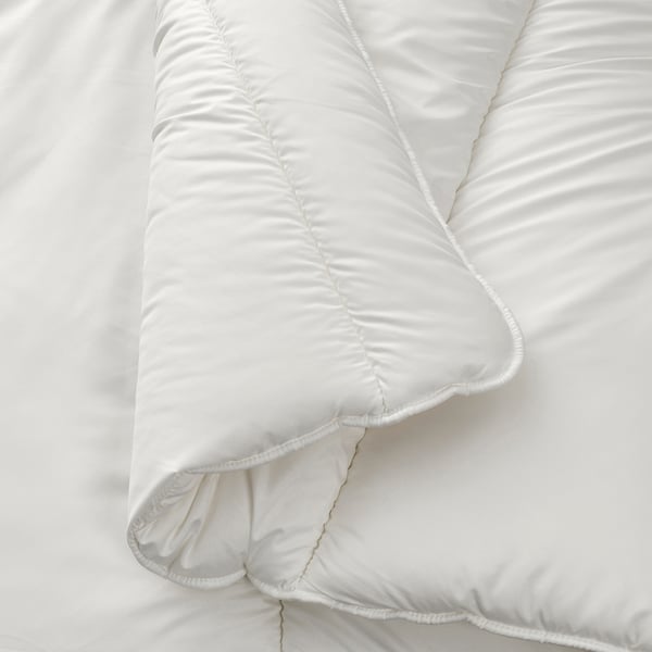 Soft, white duvet with smooth, even stitching, folded neatly on a bed. High-quality, cozy bedding with recycled materials.