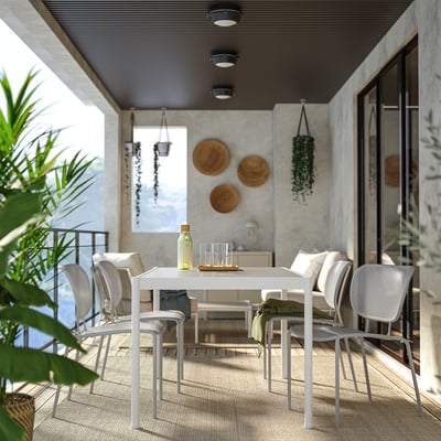 Modern outdoor dining set with SEGERÖN table and chairs. Parasol ready, minimalist, green surroundings.