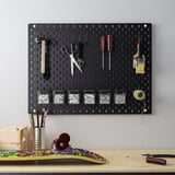 SKÅDIS black pegboard organizer with tools & containers on grey wall, compact yet spacious.