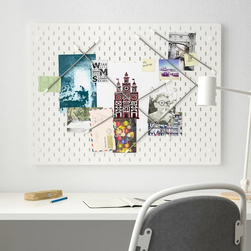SKÅDIS white pegboard with notes & photos, larger than desk & chair.