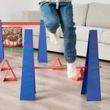 Child in blue jeans jumping over colorful obstacle course bars, promoting motor skills and fun.