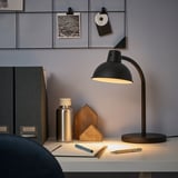 Minimalist black SKURUP lamp on desk with accessories.