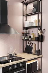 Modern kitchen with sleek black shelves, stainless appliances, pink tiles, and neatly organized cooking tools and utensils.