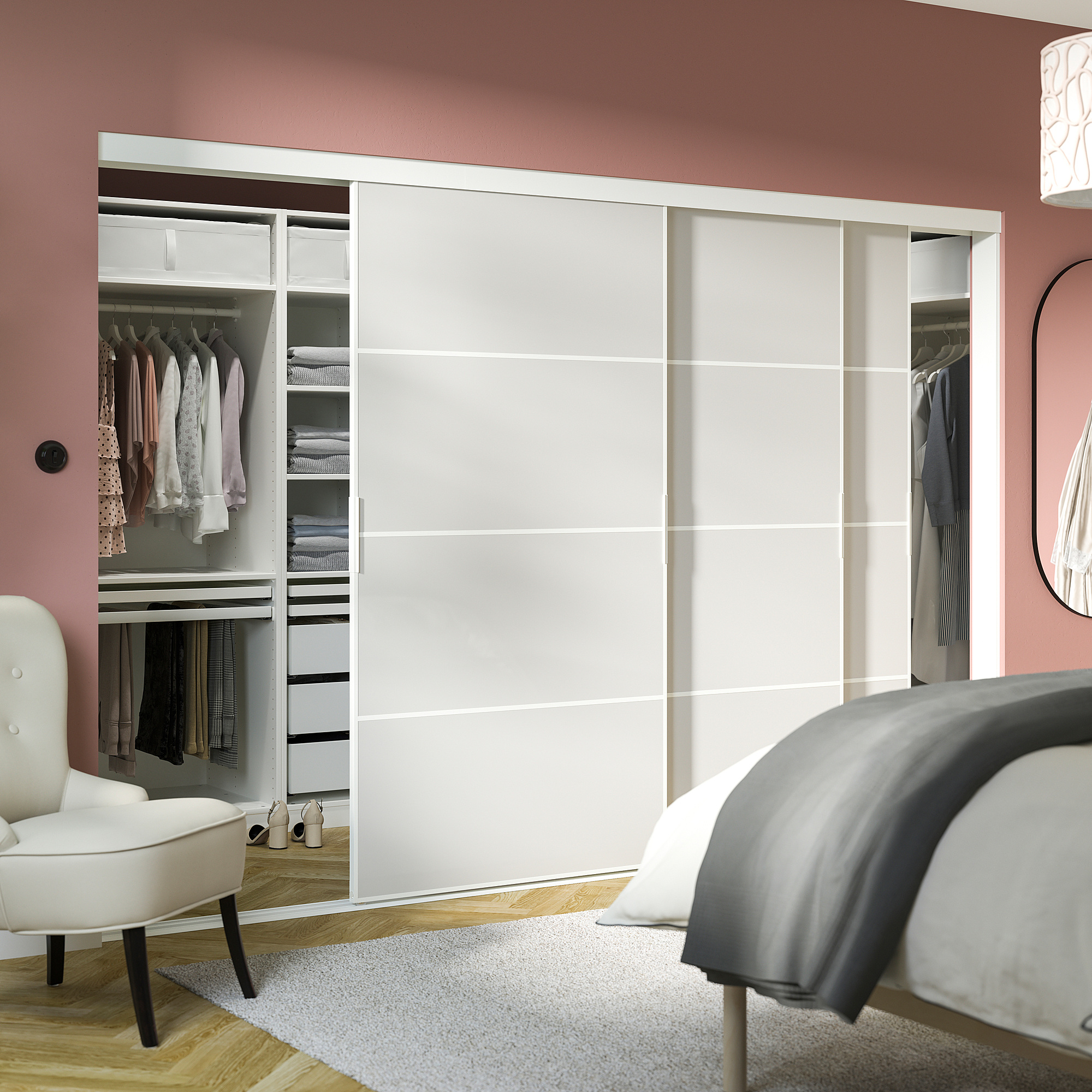 A stylish, pink-walled room with SKYTTA white closet, neatly arranged clothes, and a cozy gray rug.