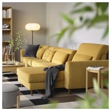 Yellow SLATORP sofa with adjustable cushions & plant in living room.