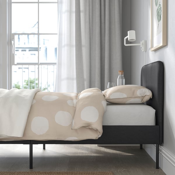 Modern bed frame, soft upholstery, clean underneath, easy assembly.