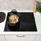 Modern kitchen scene with a steaming pan on an induction stove, showing the power boost and bridge functions.