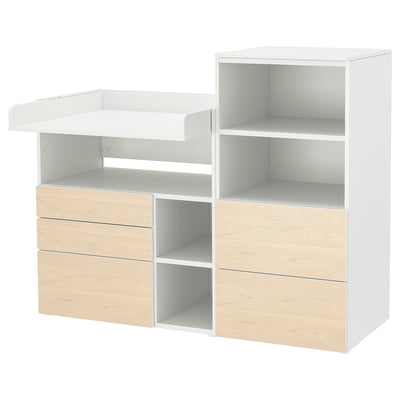 A white and light wooden changing table with storage. It has shelves, drawers, and an adjustable top.