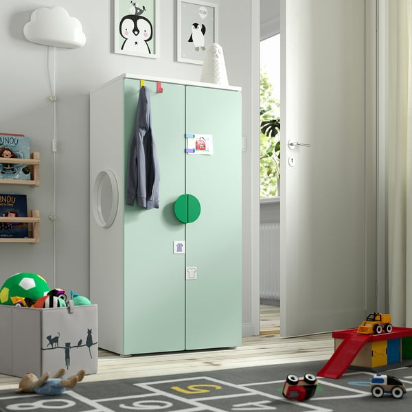 Kids room with green SMÅSTAD wardrobe. Tall, narrow, with hooks and compartments. Bright, toys on floor.