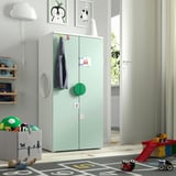 Kids room with green SMÅSTAD wardrobe. Tall, narrow, with hooks and compartments. Bright, toys on floor.
