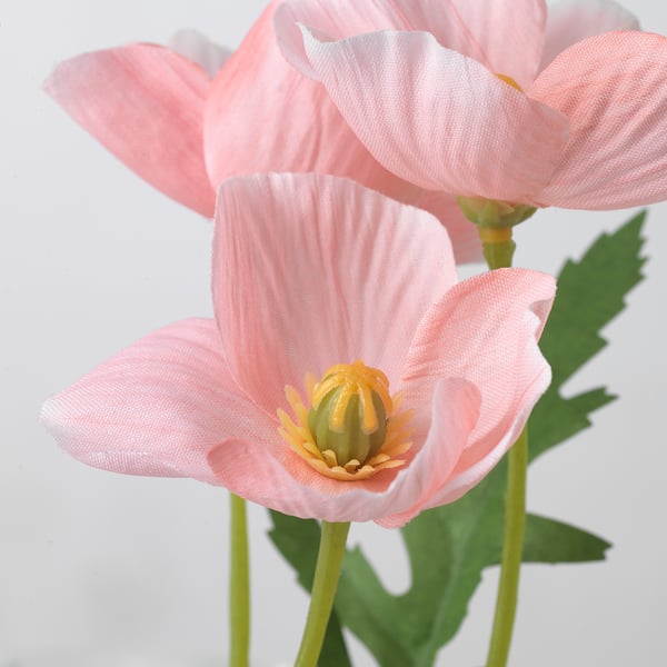 Close-up of vibrant artificial pink flowers, showcasing realistic petals and central stamen, crafted from recycled materials.