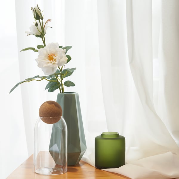 Three vases: left, center, right. White curtains.