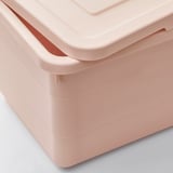 A close-up of light pink plastic storage box with lid, showcasing robust, smooth edges and secure latch mechanism.