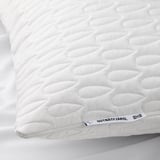 Close-up of a plush, white pillow protector, quilted with a wavy pattern, displaying branding at one corner.