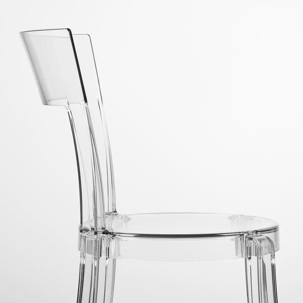 Clear, sleek chair with curved back and seat. Modern design, transparent polycarbonate body.