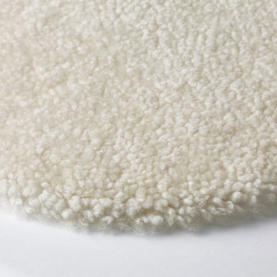 Close-up of soft, textured white sheepskin, showcasing its luxurious, plush quality.