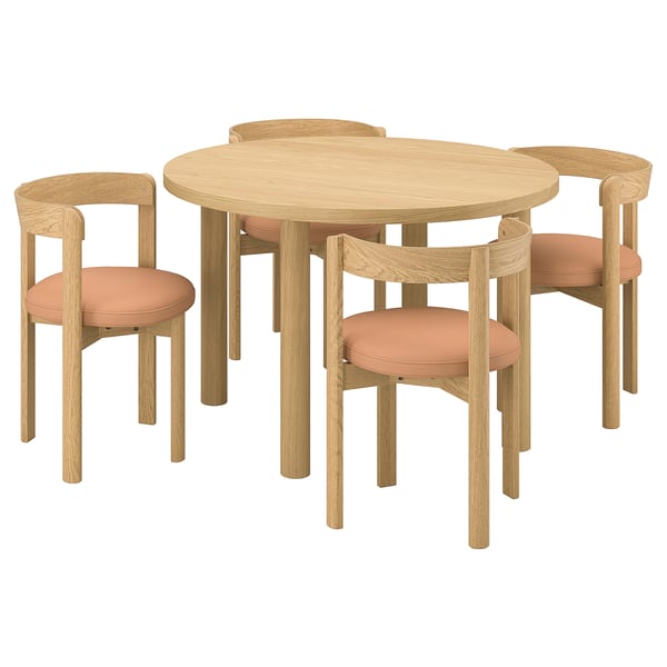 A round wooden dining table with four matching chairs. The chairs have peach-colored cushions and a modern, minimalist design.