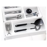 Kitchen drawer organizer with compartments for utensils, gadgets, and tools.