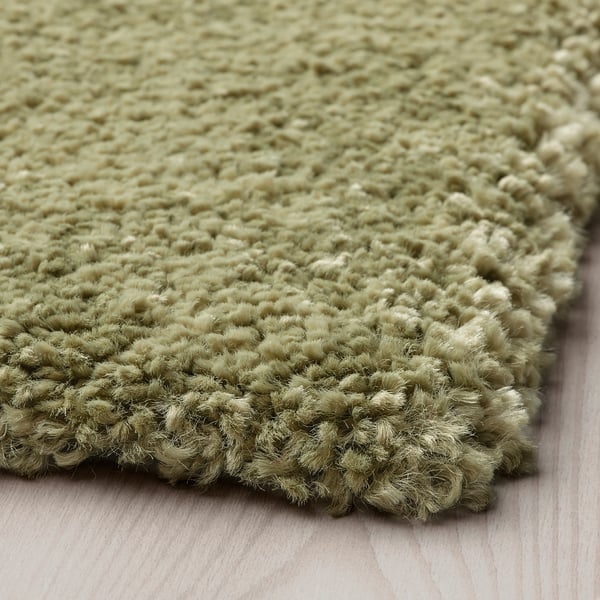 Close-up of a plush, green rug with thick, textured pile for comfort.