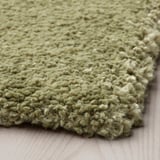 Close-up of a plush, green rug with thick, textured pile for comfort.
