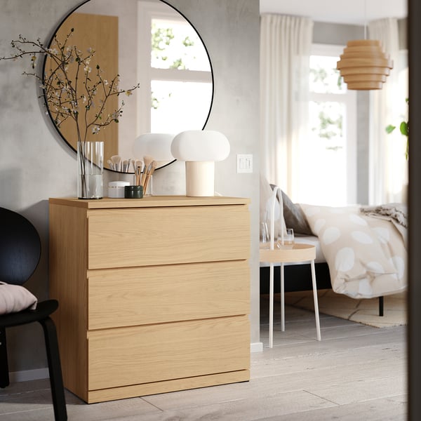 Wooden chest with three drawers, mirror above, lamps on top.