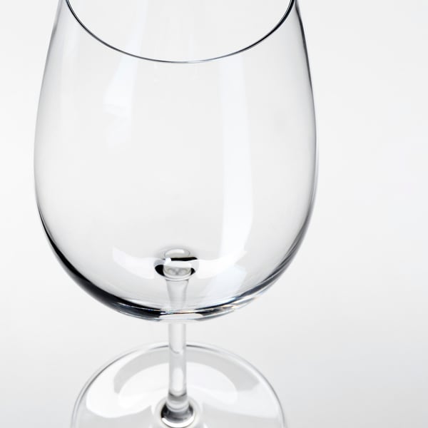 Clear, empty wine glass with smooth stem, reflecting light, set against white background.