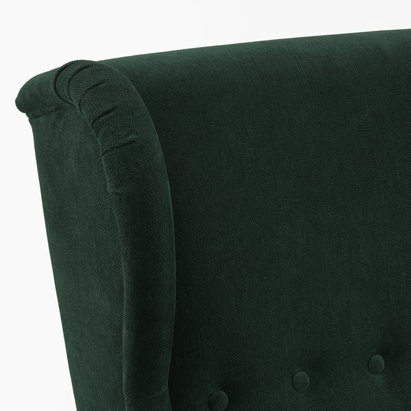 Dark green upholstered chair back with rolled armrest, showing high-quality fabric and stitching.