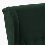 Dark green upholstered chair back with rolled armrest, showing high-quality fabric and stitching.