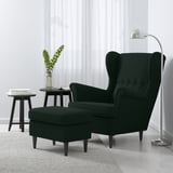 Modern living room with dark green, wingback STRANDMON chair & ottoman. Sleek design, lamp, side table, and plant. Large chair, tall lamp.