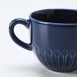 Dark blue ceramic mug with glossy finish and textured design, featuring a sturdy handle.