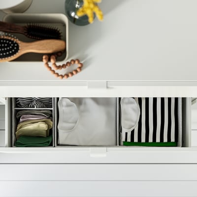 Organised drawer with sock boxes divided into compartments for tidy storage.