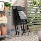 Three black metal chairs folded and stacked against a wall. Perfect for small spaces.