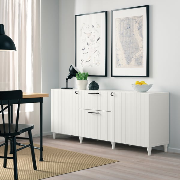 Modern living room with white sideboard, art prints, and black desk.
