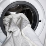 Open dryer with blanket inside, showing cleaning and drying function.