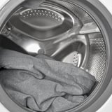 Washing machine drum with sweater inside.