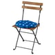 A TÄRNÖ outdoor chair with a blue polka-dotted cushion.
